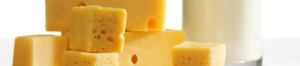 Collection of cheeses and a glass of milk on a table