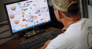 Farmer looks at flow graph on computer