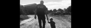 Little boy holding hands with grandfather walking away together