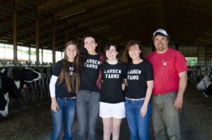Larsen farm family poses for NMPF Farmer Focus in their cow barn