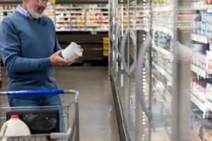 Mature adult man checks label on container